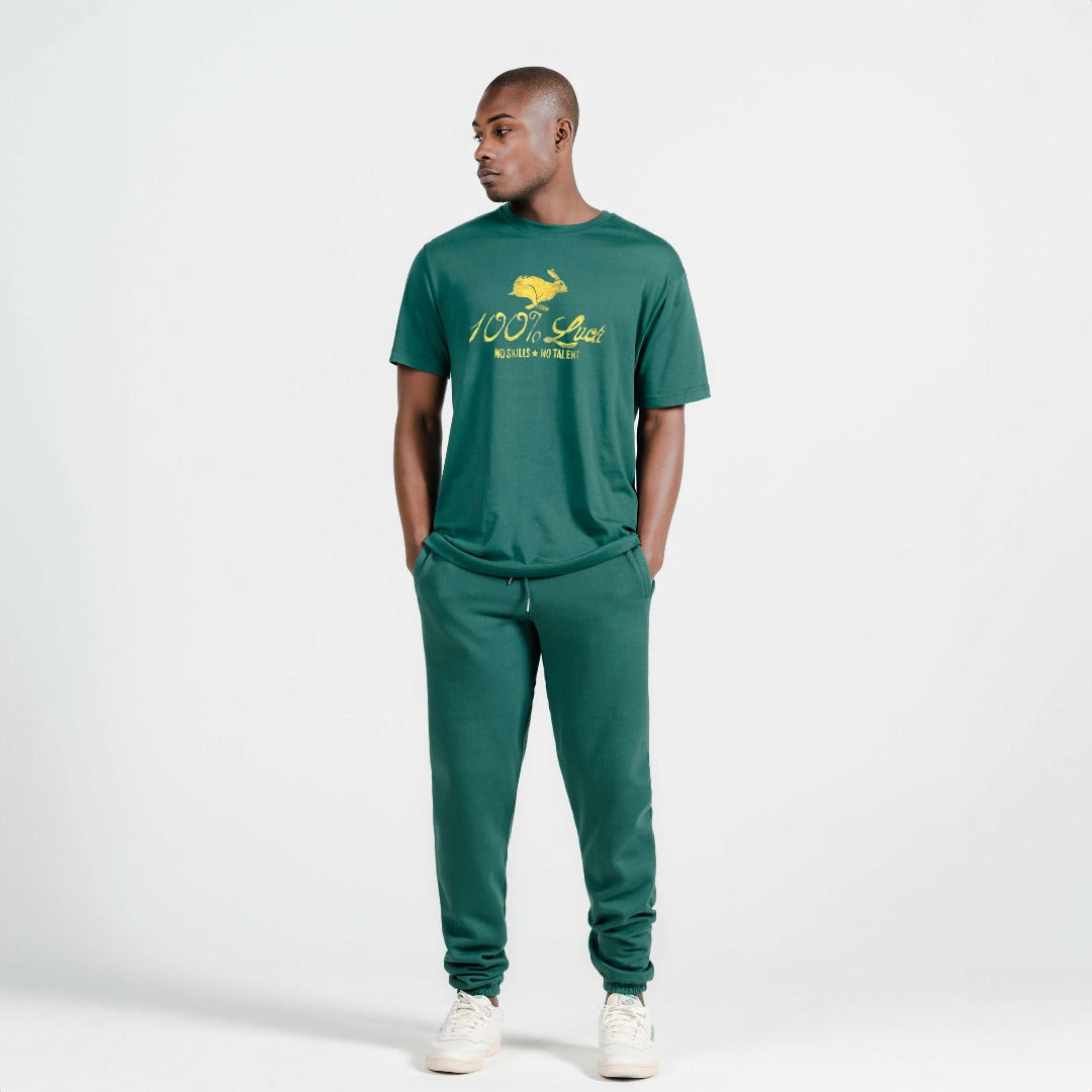 A young man poses in a Bayberry tshirt with artwork of a rabbit with the words: "100% Luck. No Skills. No Talent" below the rabbit.