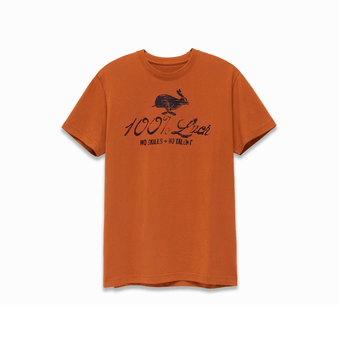 Clay color t-shirt with black artwork of a rabbit with the words: "100% Luck. No Skills. No Talent" below the rabbit.