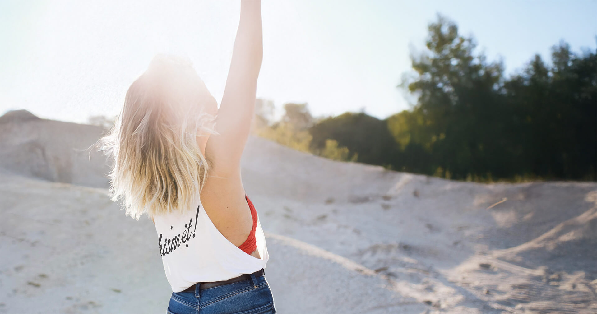 Person with arms raised in a desert landscape