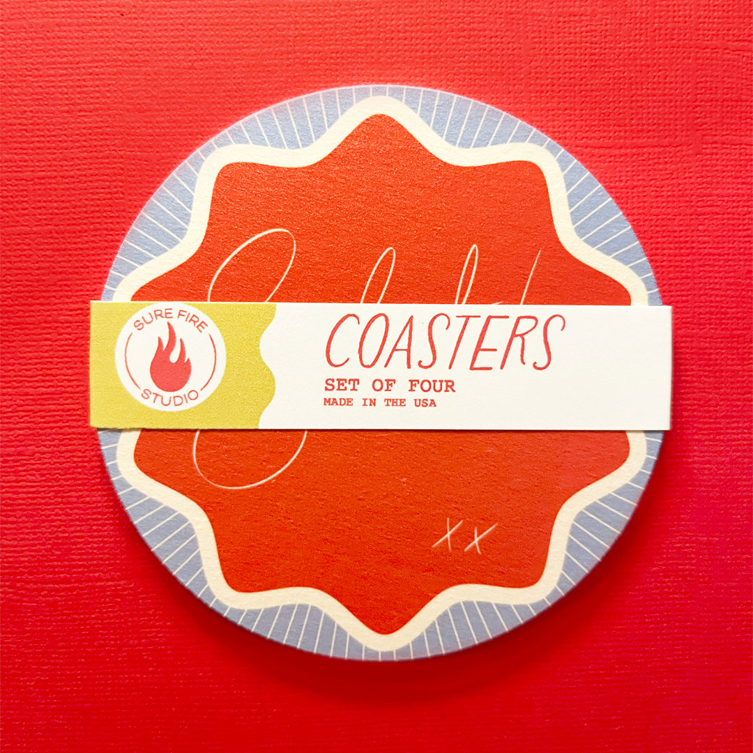 Coaster set of pulpboard coasters that read "Salut!" in script on a red background with a wavy border.